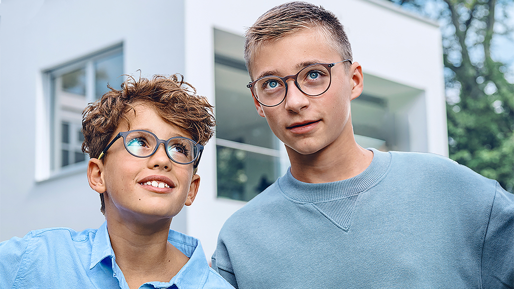 Младо момче гледа към тийнейджър, и двамата с очила ZEISS Single Vision SmartLife Young